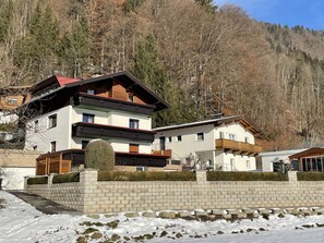 Situated in a mountainous area, this chalet offers a balcony with a stone wall and wooden railings.