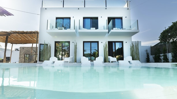 Un moderno edificio de dos pisos con una piscina delantera.