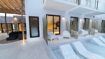 Een buitenzwembad en ligstoelen