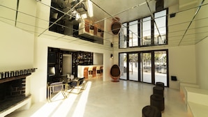 Un interior espacioso y moderno con chimenea, zona de estar y ventanas amplias.