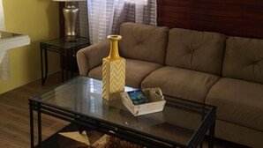 A living room with a glass coffee table, a beige sofa, a lamp, and a decorative vase. - Captivating Mountain Views, Ocean Views,  Romantic getaway (Anse La Raye)