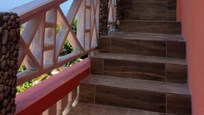 A staircase with stone steps and a red handrail, leading to a balcony with a view of the sky and clouds. - Captivating Mountain Views, Ocean Views,  Romantic getaway (Anse La Raye)