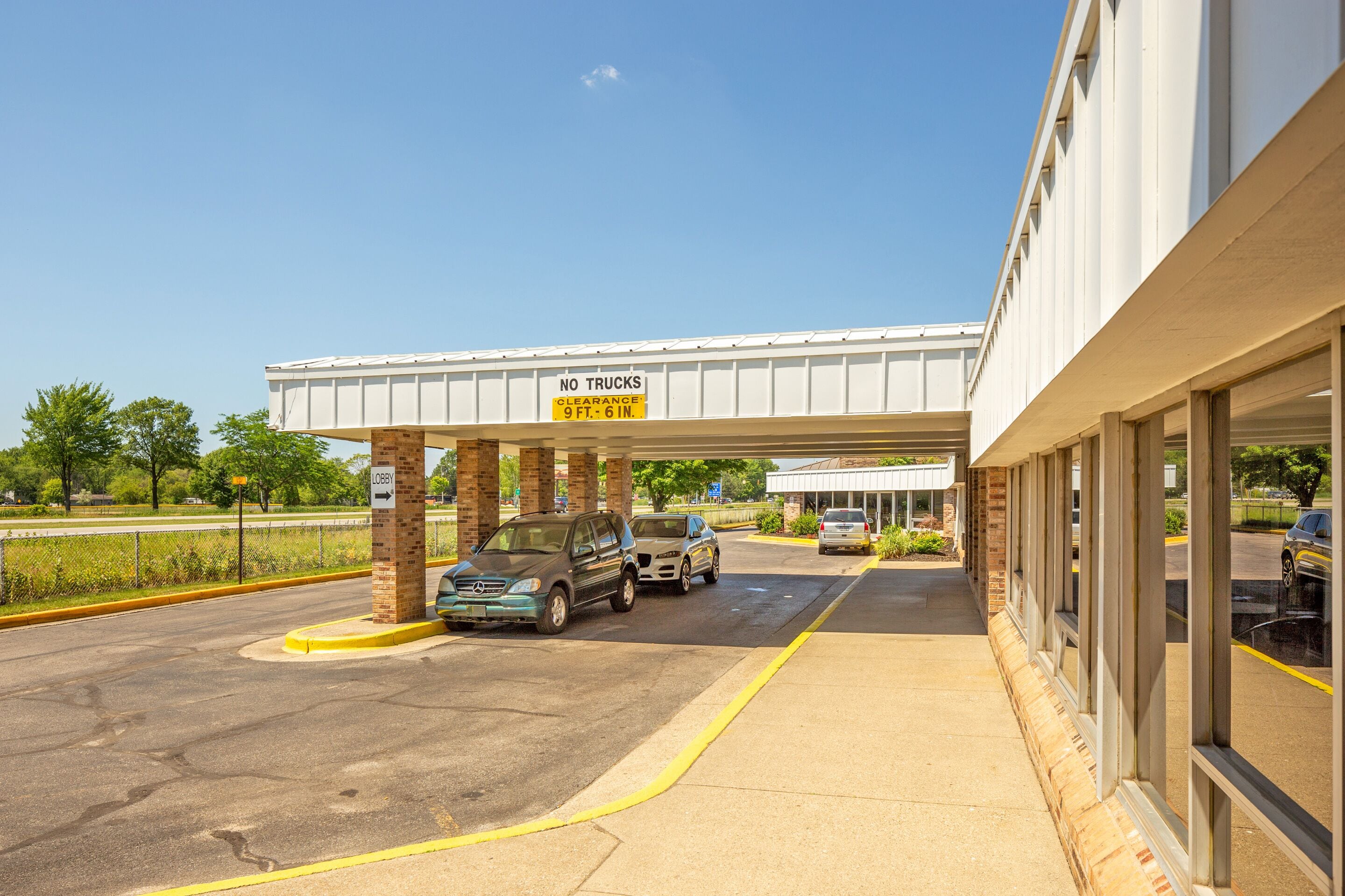 A building with a 'NO TRUCKS' sign and a 'CLEARANCE 9 FT. 6 IN.' sign.