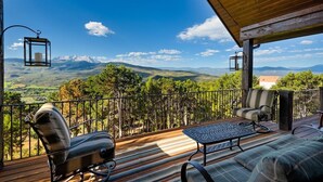 A balcony with a view of snow-capped mountains, a wooden deck, and outdoor furniture. - 10-Acre Mid-Valley Retreat with Hot Tub, Game Room & Sopris Views (Carbondale)