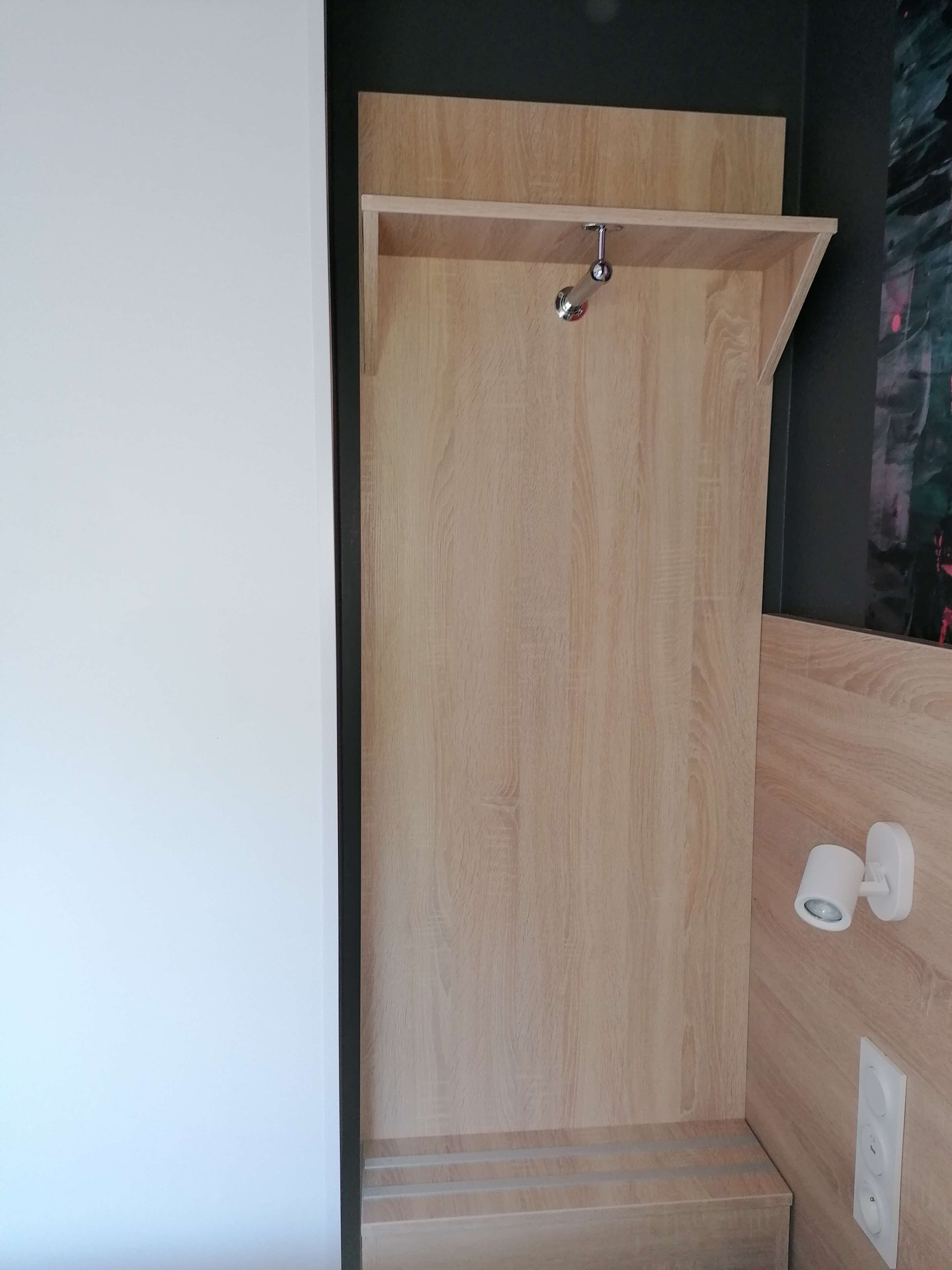Aseo de ducha con estructura de madera, repisa sobre la puerta y un escalón para entrar.