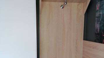 Aseo de ducha con estructura de madera, repisa sobre la puerta y un escalón para entrar.