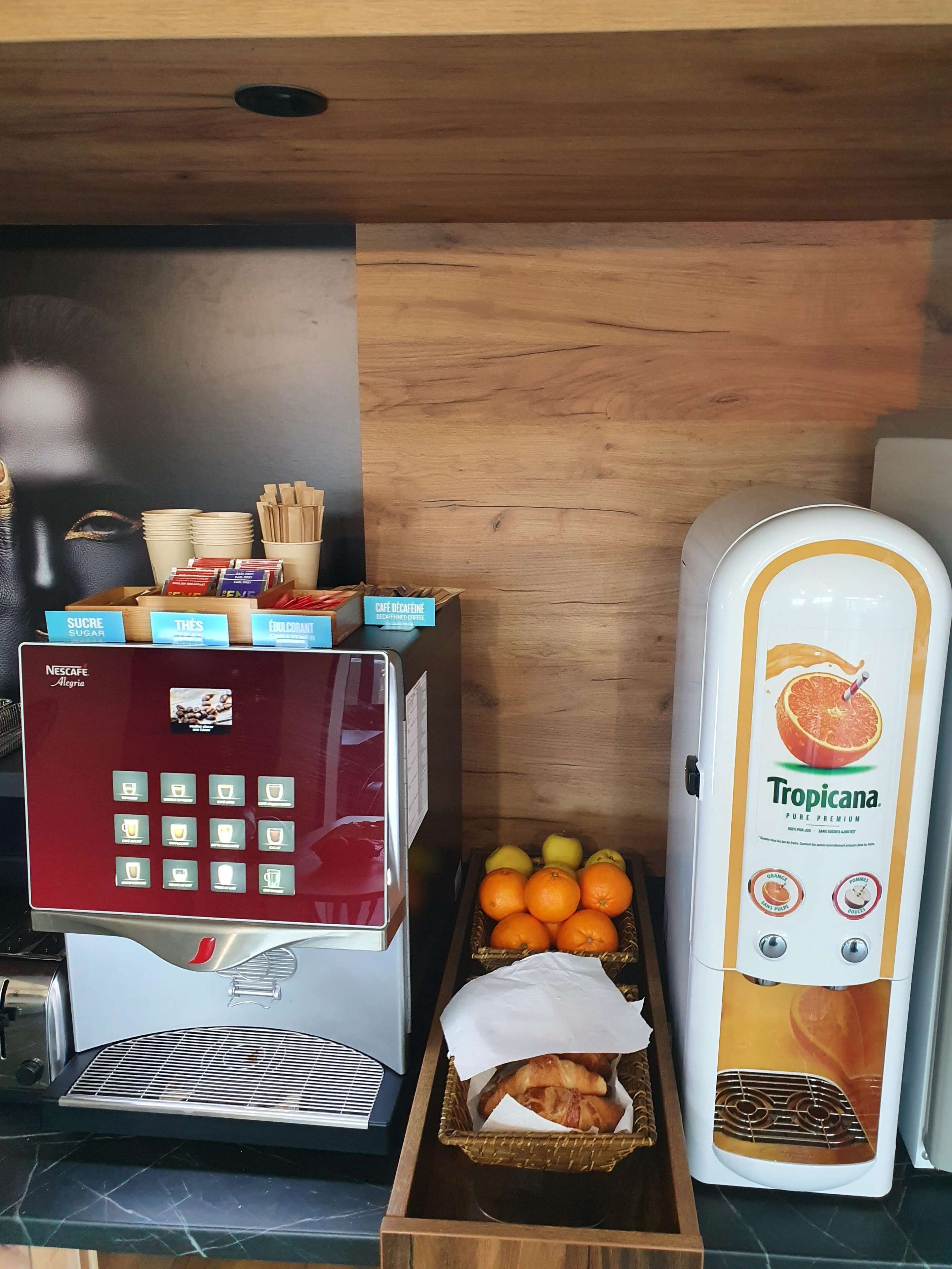 Une machine à café dotée d’un écran tactile, d’un distributeur de fruits et d’un panier de viennoiseries.