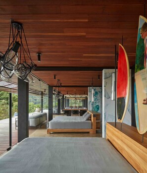 A modern bedroom with a large bed, a dining area, and a view of the outdoors. - Atelier NEW design creation at Art Villas (Uvita)