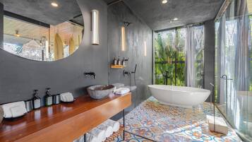 A modern bathroom with a freestanding bathtub, a wooden vanity, and a large mirror.