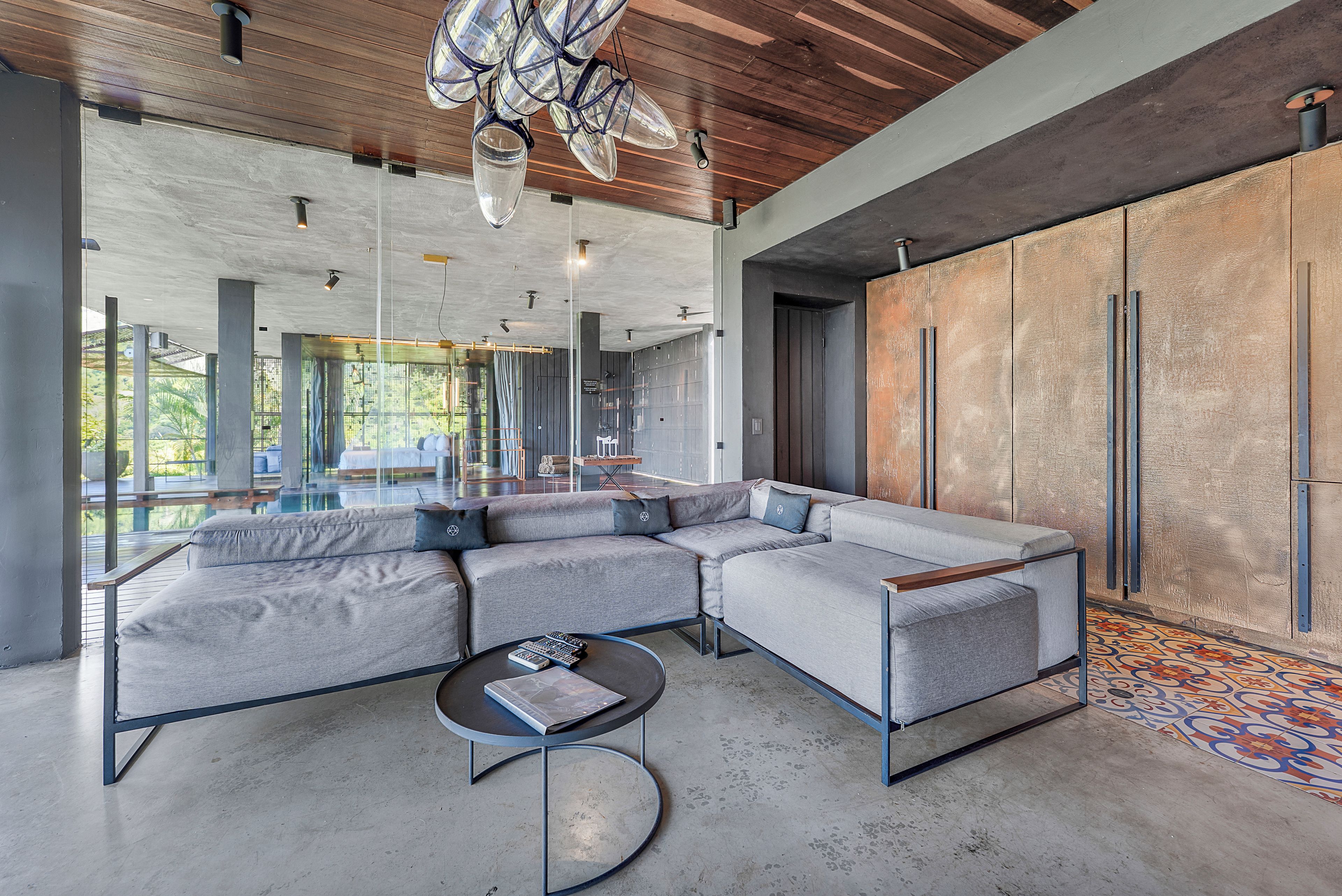 A modern living room with a sectional sofa, a coffee table, and a view of the outdoors.