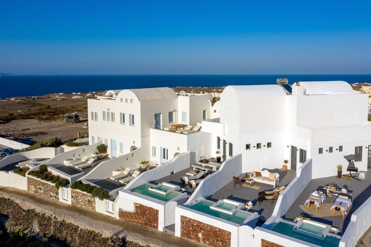 Un bâtiment blanc doté de nombreuses terrasses sur le toit, chacune comprenant une piscine et un espace salon.
