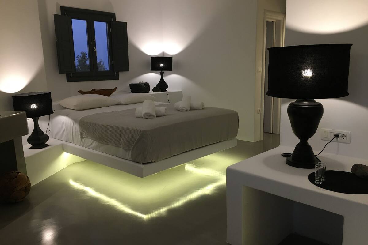 Une chambre à coucher moderne avec un lit, des lampes de chevet, une table de chevet et une commode.