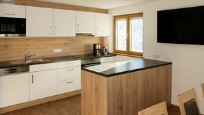 Una cocina moderna con armarios de madera, una isla integrada y un ventanal grande.