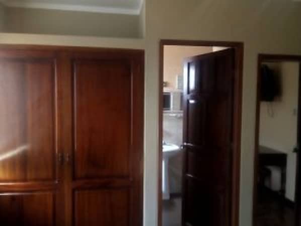 Una habitación con un armario de madera y una puerta que da a otra estancia.