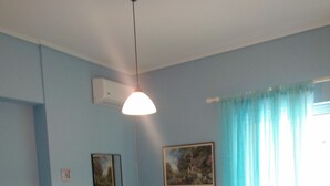 A bedroom with a bed, a blue dresser, a radiator, and a window with curtains. - Palinas comfy home!! (Kalamata)