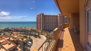 Ein Wolkenkratzerhotel mit Balkon und Blick auf Strand und Meer.