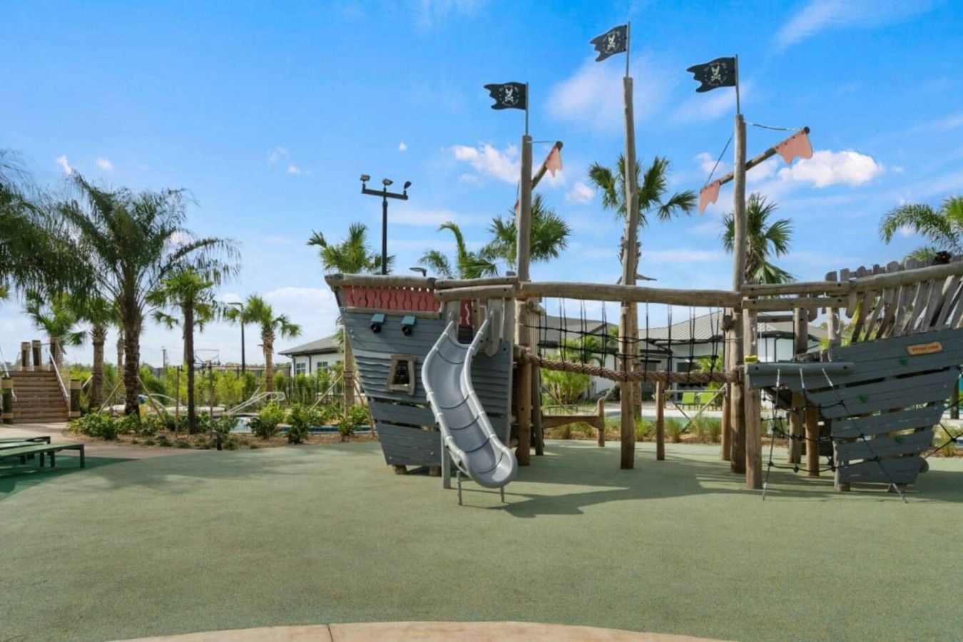 A playground with a slide, climbing structures, and a pirate-themed design.