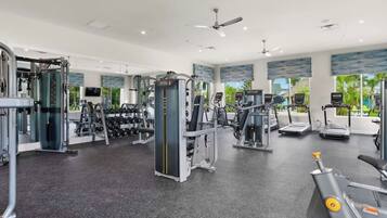 A gym with various exercise equipment, including treadmills, weight machines, and free weights.