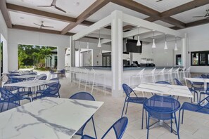 A spacious indoor dining area with high ceilings, white pillars, and blue chairs. - Resort/Private Pool! Near Disney!Sleeps13 (Kissimmee)