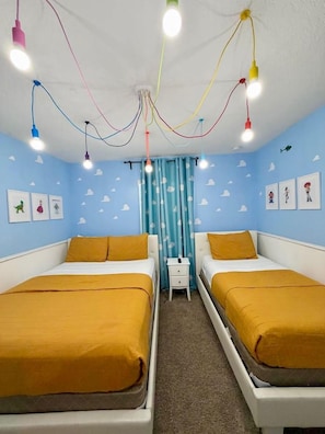 A room with two beds, a nightstand, and a ceiling with colorful hanging lights. - Resort/Private Pool! Near Disney!Sleeps13 (Kissimmee)