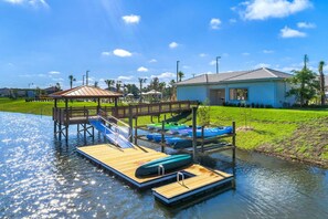 A water park with a wooden dock, a slide, and several boats. - Resort/Private Pool! Near Disney!Sleeps13 (Kissimmee)
