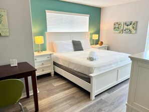A bedroom with a bed, bedside tables, a chair, and a desk. - Resort Home Sleeps 12 w/private Pool! (Kissimmee)