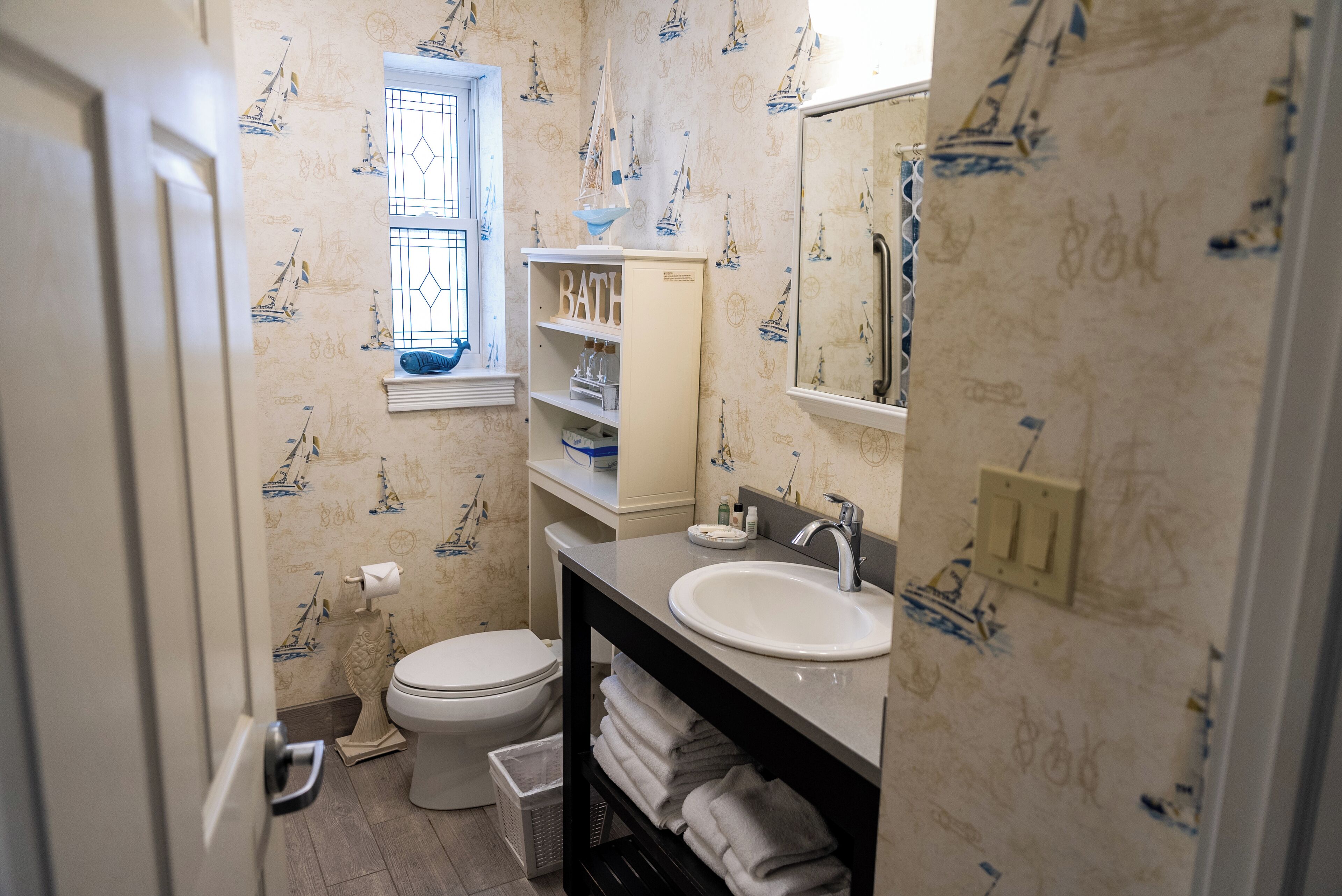 A bathroom with a toilet, sink, and vanity.