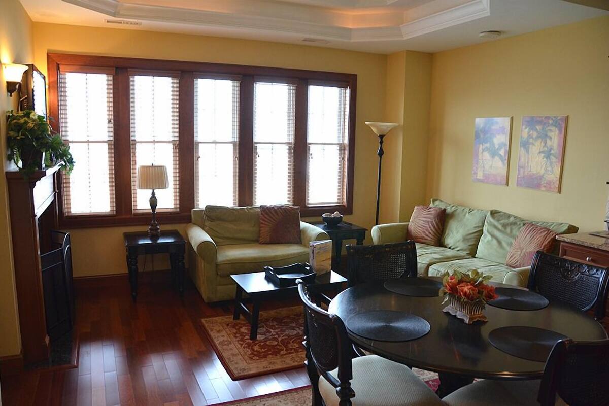 A living room with a sofa, a dining table, and a lamp.