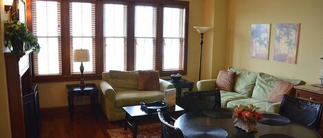 A living room with a sofa, a dining table, and a lamp.