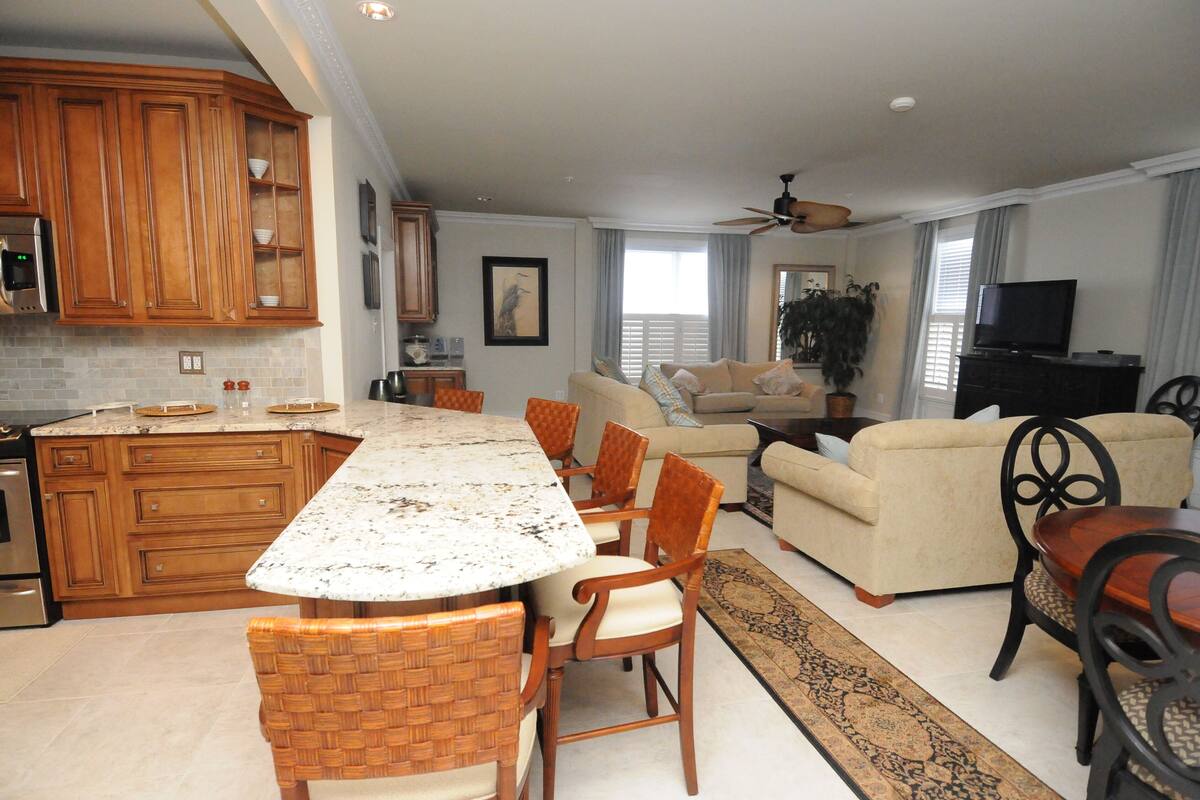 A spacious living area with a large island, a sofa, and a television.