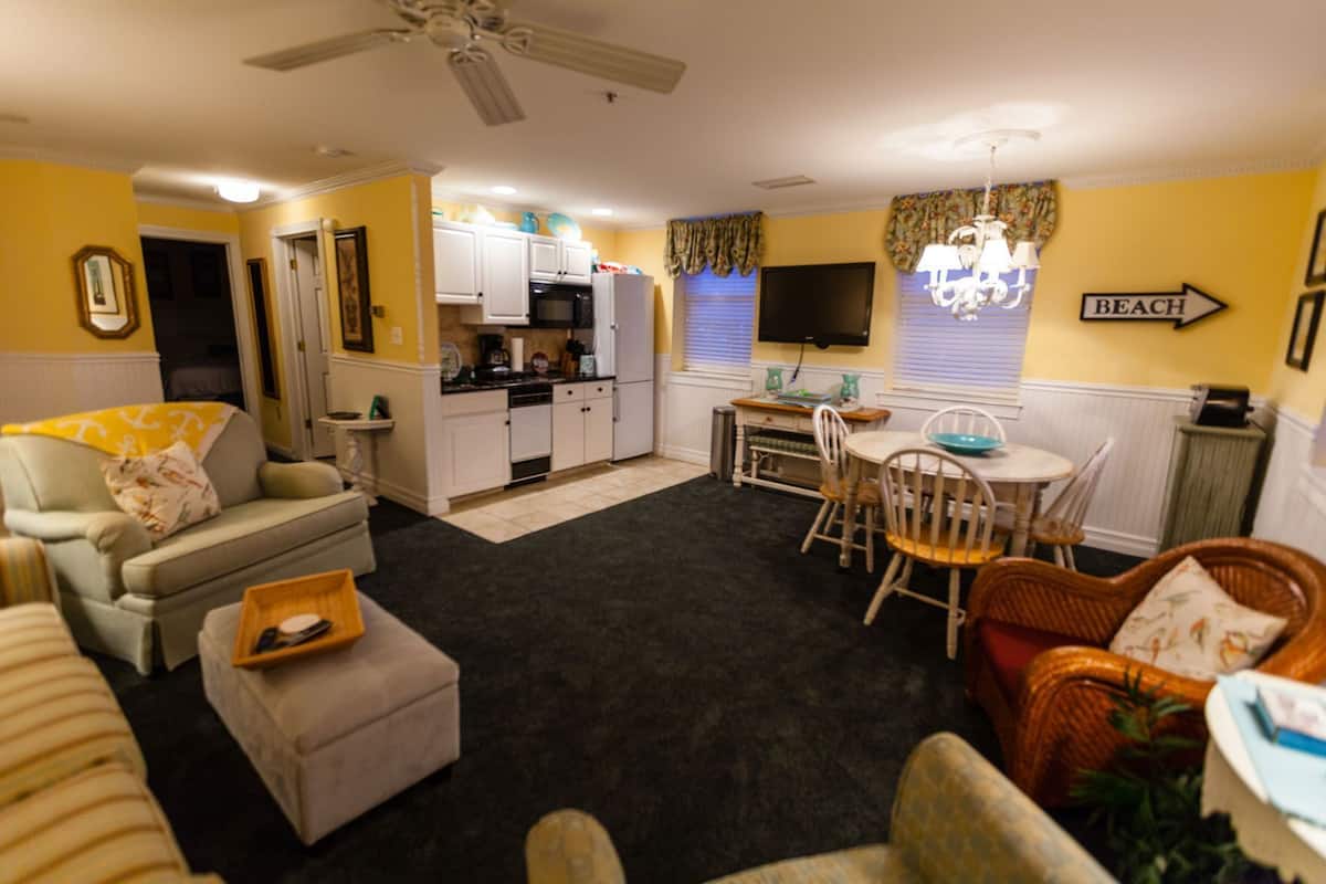 A compact living space with a kitchenette, dining area, and seating.