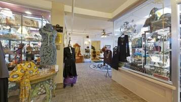 A boutique with various clothing items on display, including dresses and coats.