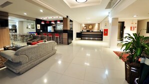 A hotel lobby with a reception desk, seating area, and a bar. - Hotel Klein Vllle Plus (Dois Irmaos)