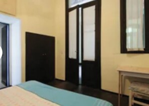 A room with a bed, a door, and a window.