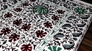 Tecido estampado com desenhos florais e folhagens.
