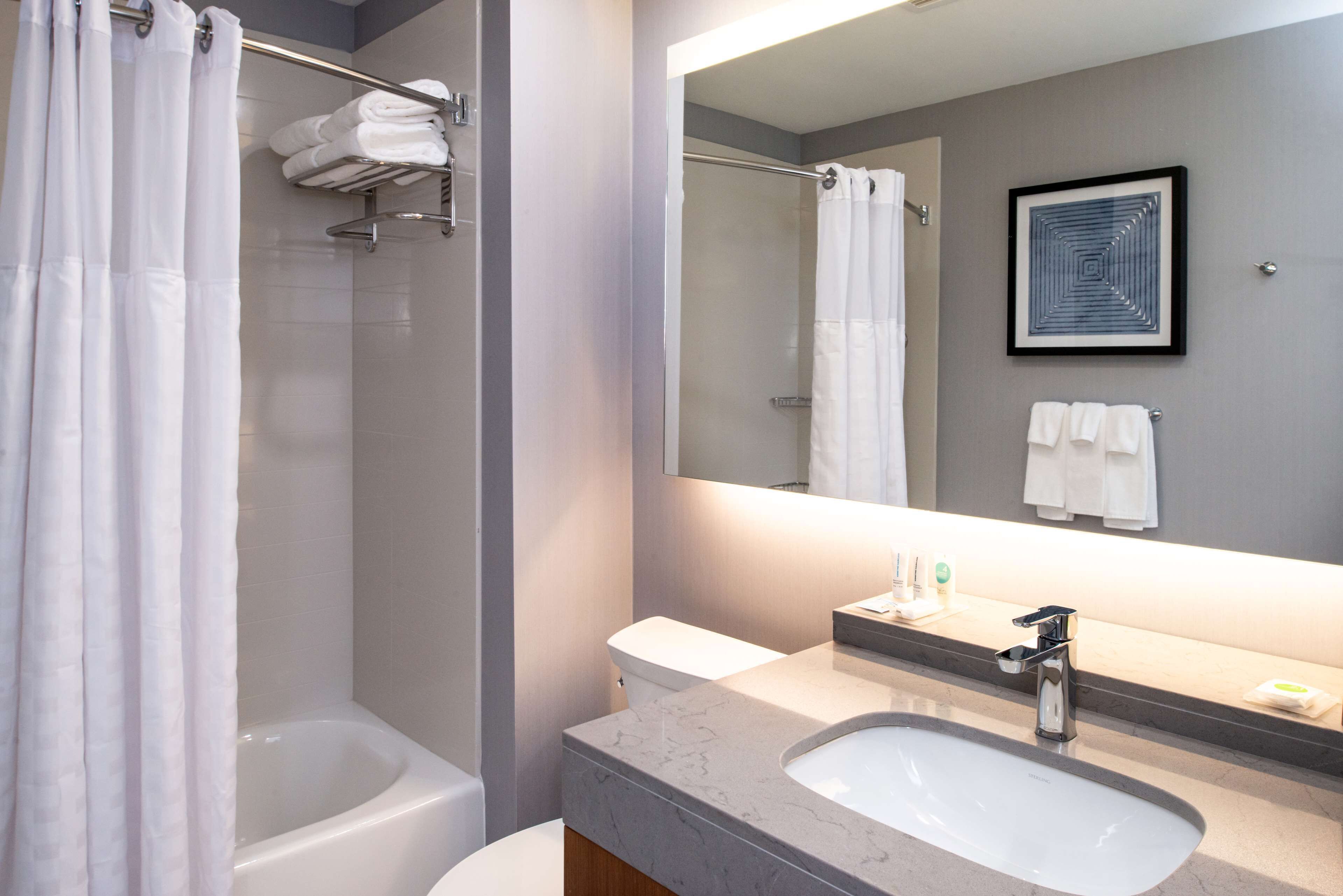 A modern bathroom with a bathtub, toilet, and sink.