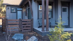 A modern house with a porch, wooden gate, and two chairs. - Bluebird Day - River Trail House, Enjoy a cozy retreat in Bend, OR. (Bend)