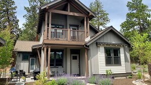 A two-story house with a balcony, a covered patio, and a small attached garage. - Bluebird Day - River Trail House, Enjoy a cozy retreat in Bend, OR. (Bend)
