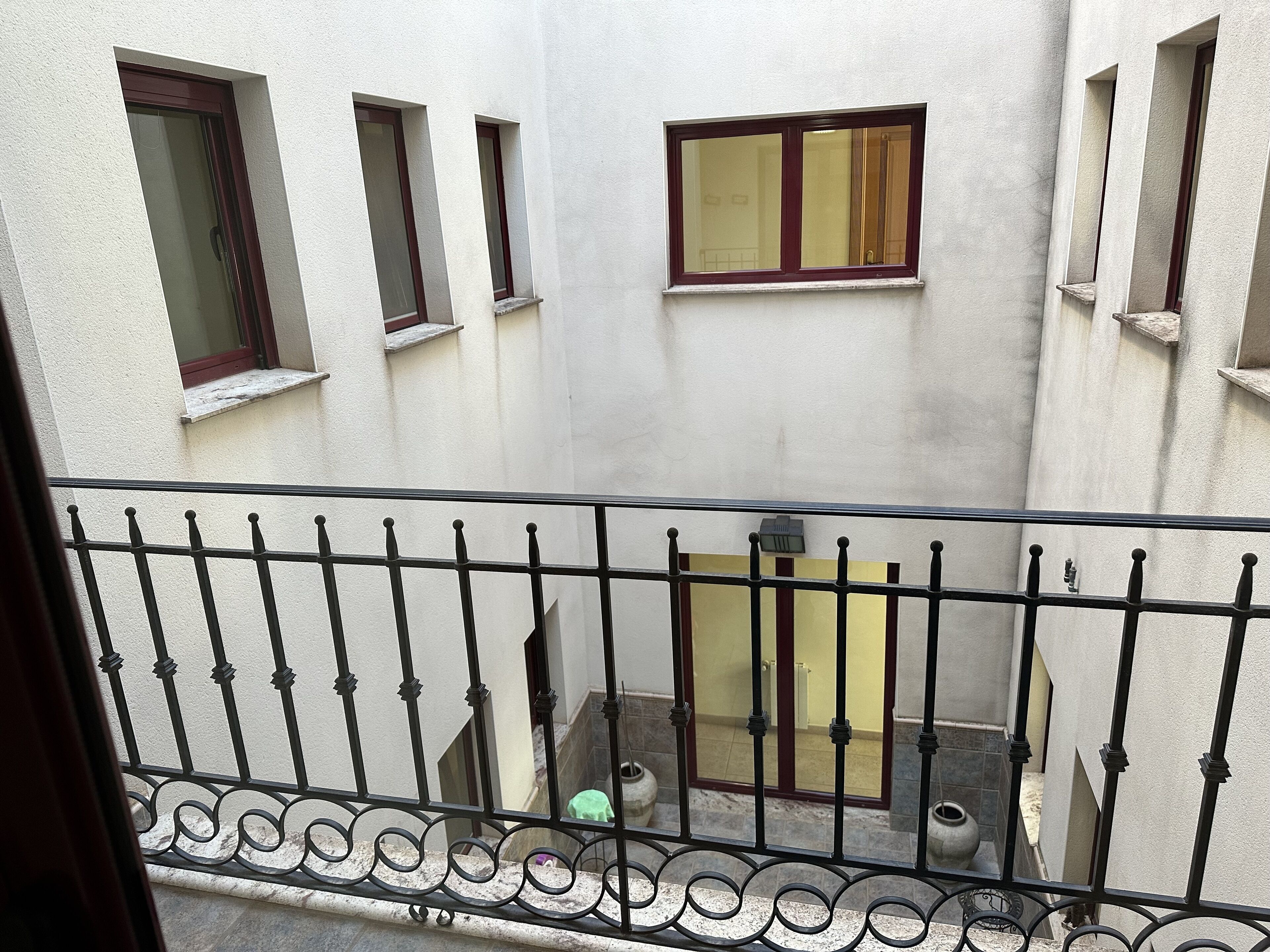 A view of a building with multiple windows and a balcony with decorative iron railings.