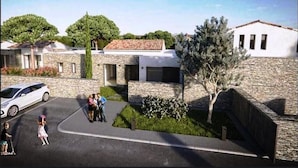 Una zona residencial con edificios de piedra, un camino pavimentado y un estacionamiento.
