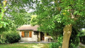 A small house with a tiled roof, a front door, and a small patio with a table and chairs. - Stunning private villa for 6 guests with WIFI, TV, terrace and pets allowed (Arès)