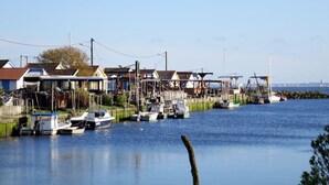 A waterfront marina with boats docked, houses along the shore, and a clear view of the water. - Stunning private villa for 6 guests with WIFI, TV, terrace and pets allowed (Arès)
