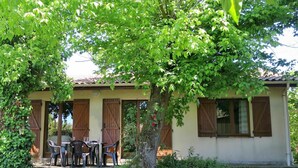 A building with a covered patio, a table with chairs, and a tree in front. - Stunning private villa for 6 guests with WIFI, TV, terrace and pets allowed (Arès)