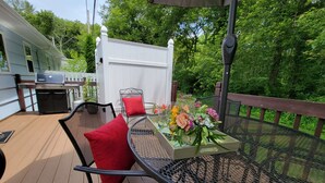 A deck with a grill, outdoor seating, and a table with flowers. - Discount ! A mile to Narragansett beach & Boon Street Market this home has it all ! (Narragansett)