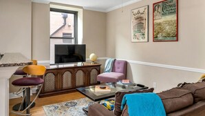 Ein Wohnzimmer mit Fernseher, Globus, Sofa und Couchtisch.