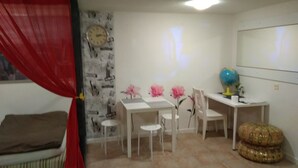 A room with a bed, a desk with chairs, a globe, and a clock on the wall. - APARTAMENT W CENTRUM NOCLEGI PŁOCK (Plock)