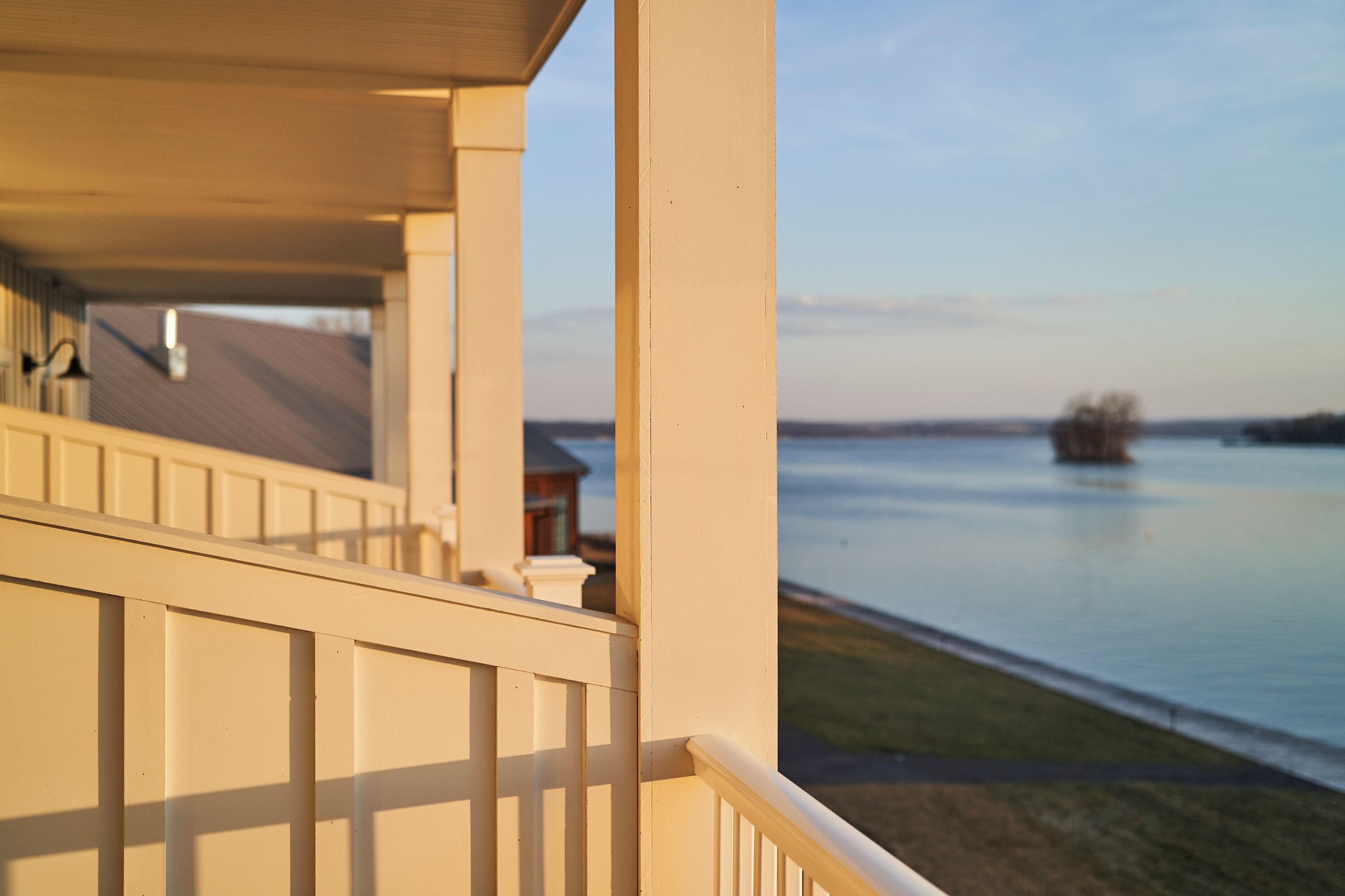 Ein Balkon mit Blick auf ruhiges Wasser und entfernte Küste.