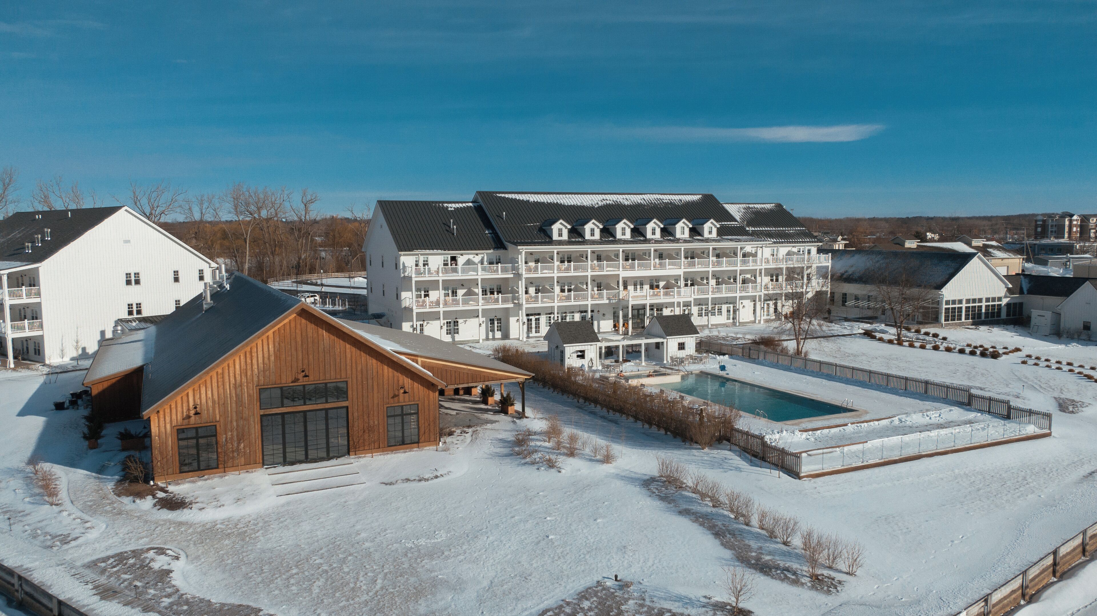 Un grand complexe hôtelier comprenant plusieurs bâtiments, une piscine et un paysage enneigé.