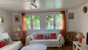 Ein gemütliches Wohnzimmer mit einer Couch, einem runden Couchtisch und einem Fernseher auf einem Lowboard.
