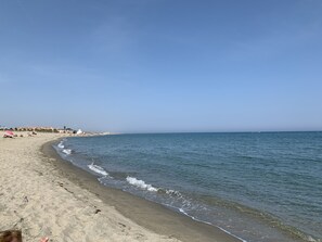 Een strand met een zandstrand en rustige zee.